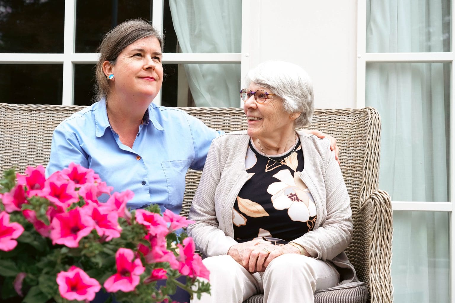 Bewoner met medewerker op bankje
