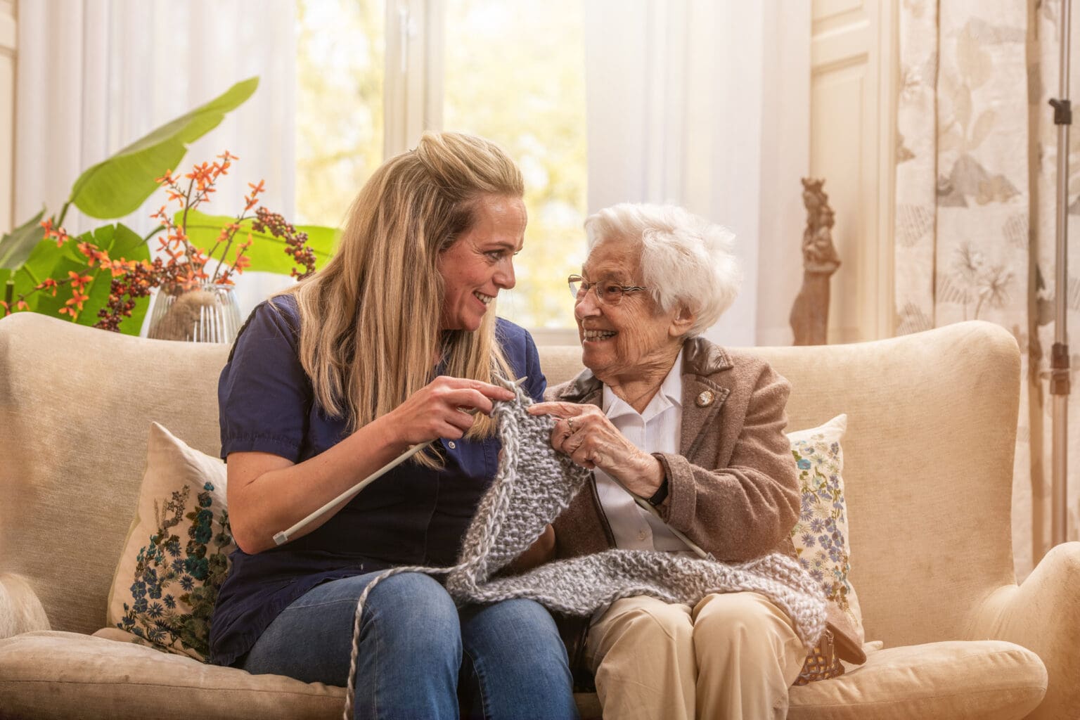 Bewoner is aan het breien samen met medewerker