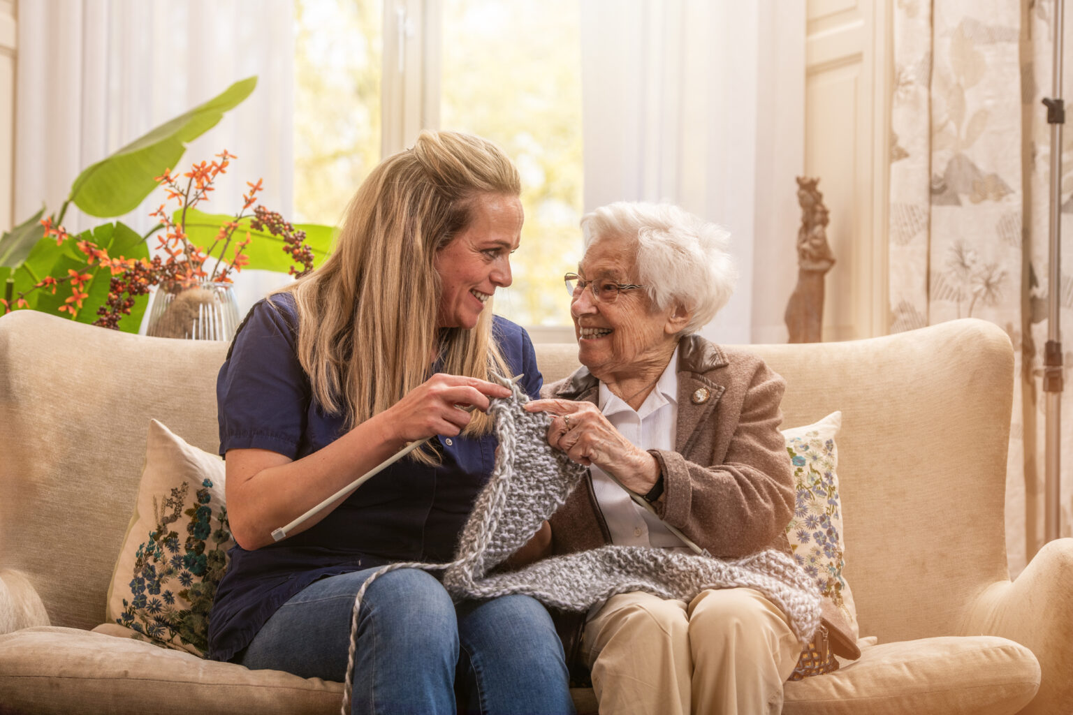 Bewoner is aan het breien samen met medewerker
