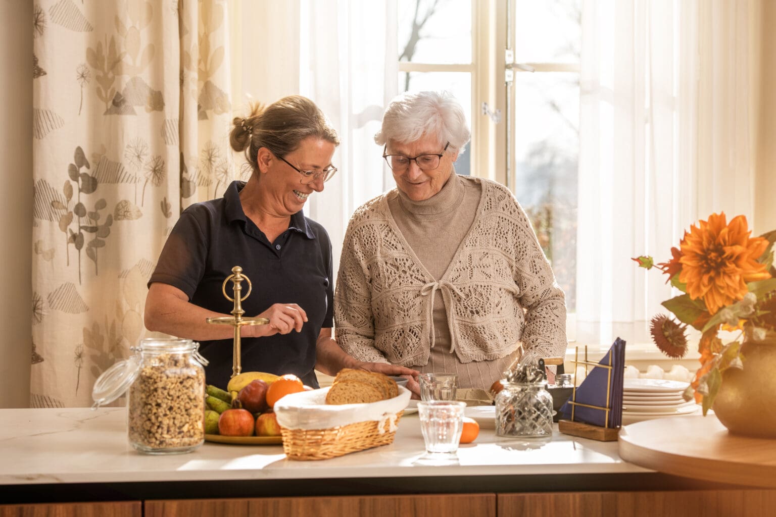 Bewoner met medewerker in de keuken